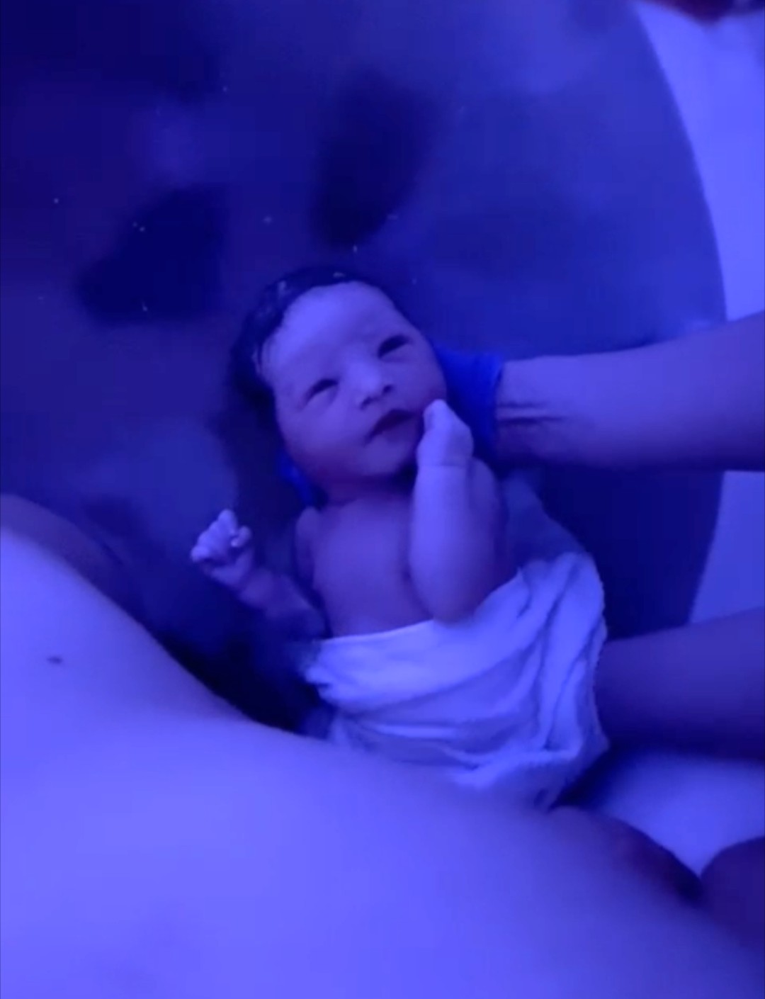 Joelle holding a newborn during a postnatal visit
